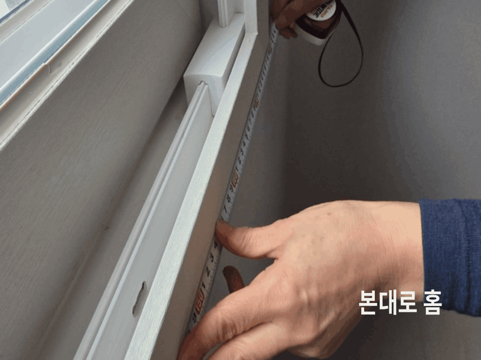 창 크기를 줄자로 정확히 실측하는 모습